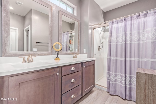 bathroom with hardwood / wood-style flooring, walk in shower, and vanity