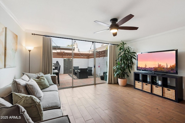 living room featuring ceiling fan, wood-type flooring, ornamental molding, and a wealth of natural light