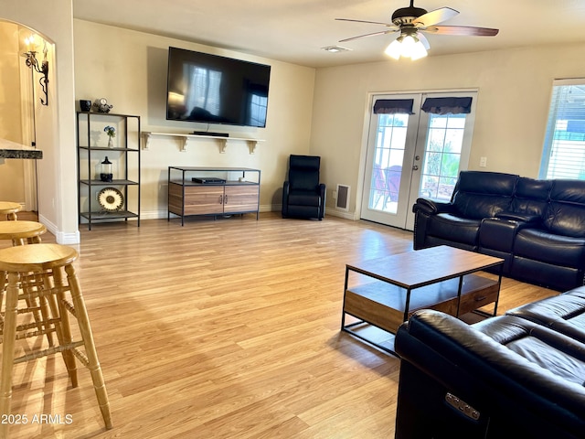 living room with visible vents, french doors, light wood-style flooring, and baseboards