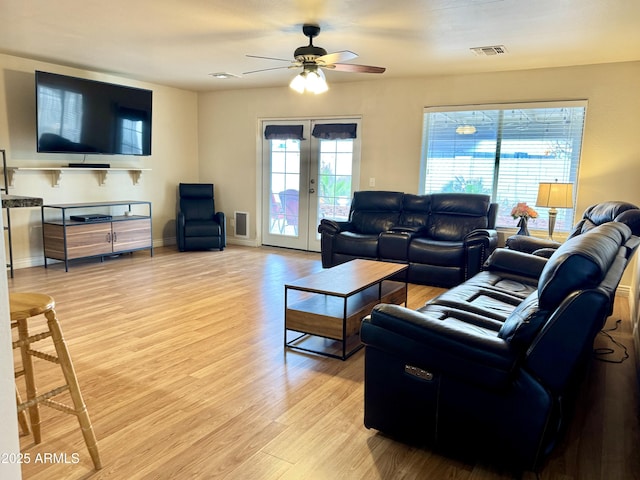 living area with visible vents, baseboards, a ceiling fan, light wood-style floors, and french doors