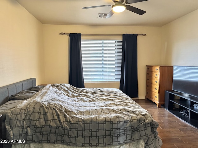 bedroom with a ceiling fan, visible vents, and wood finished floors