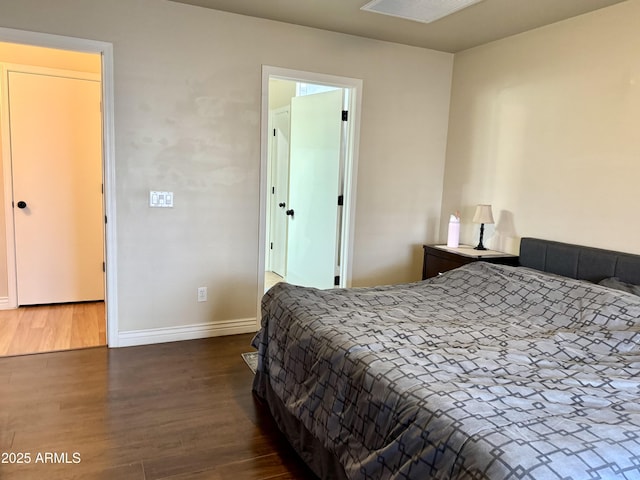 bedroom featuring visible vents, baseboards, and wood finished floors