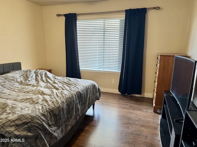 bedroom featuring dark wood-style floors and baseboards