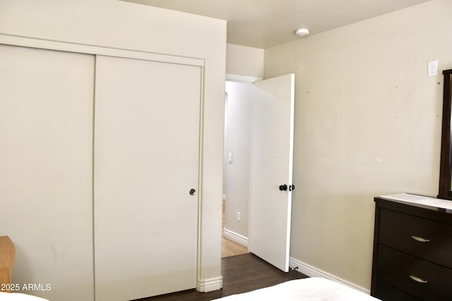 unfurnished bedroom featuring dark wood-type flooring and a closet