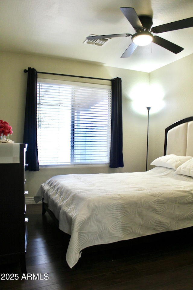 bedroom with visible vents, ceiling fan, and wood finished floors