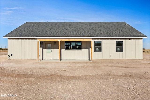 rear view of house featuring roof with shingles