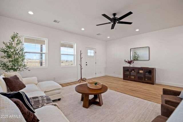 living room with light wood finished floors, baseboards, visible vents, and recessed lighting