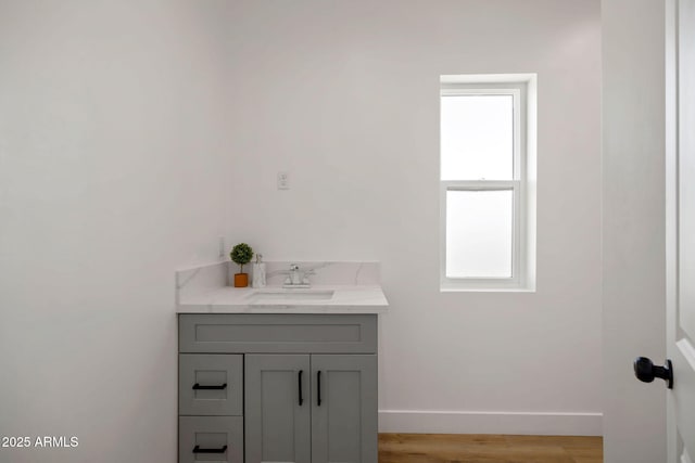 bathroom with baseboards, wood finished floors, and vanity