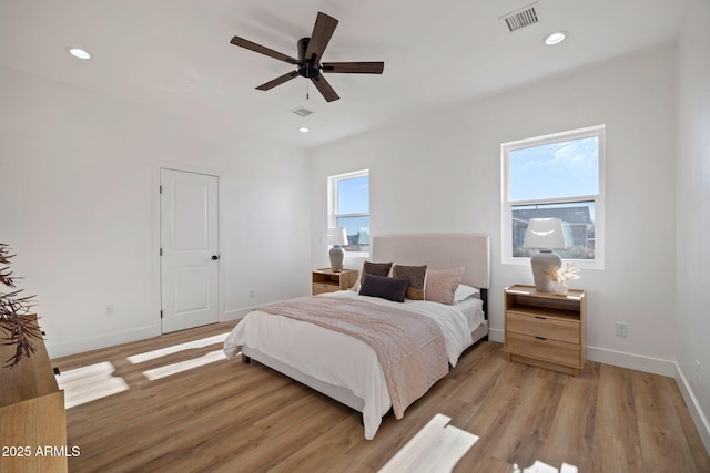 bedroom featuring visible vents, light wood-style flooring, and multiple windows