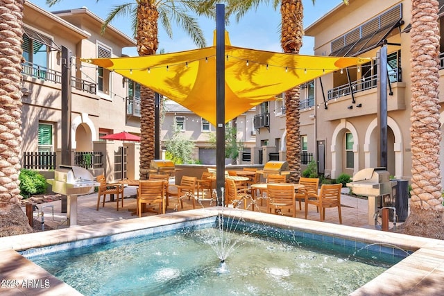 view of swimming pool featuring a patio area, a wall unit AC, and area for grilling