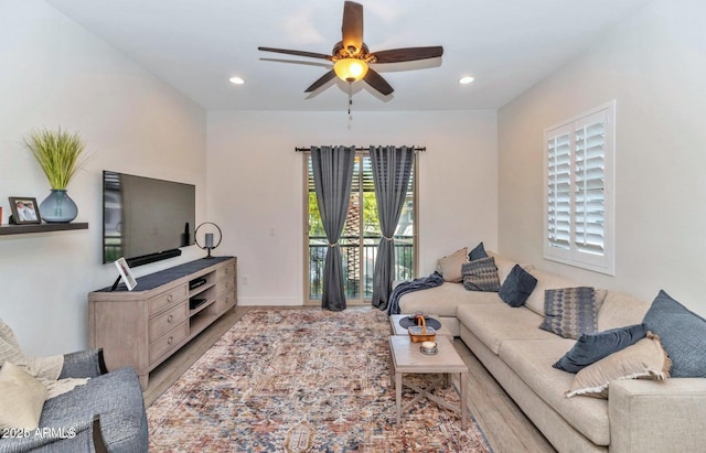 living room featuring ceiling fan and light hardwood / wood-style floors