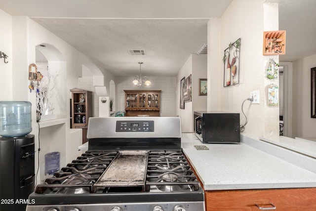 4403 N 56th Dr, Phoenix, AZ 85031 - kitchen featuring stainless steel range with gas cooktop, arched walkways, and a chandelier
