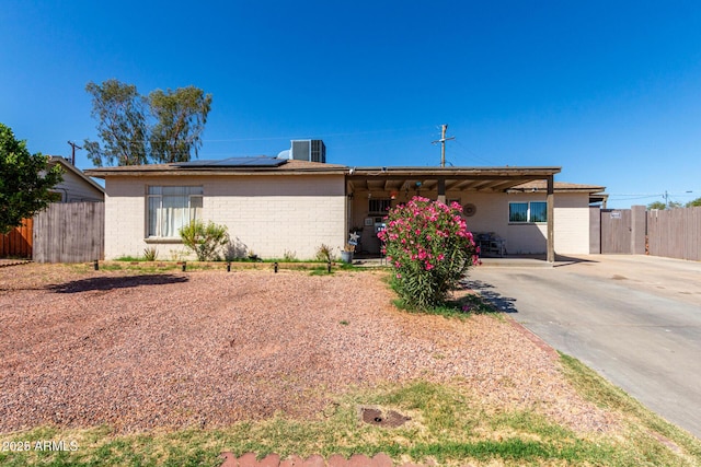 4403 N 56th Dr, Phoenix, AZ 85031 - ranch-style house featuring roof mounted solar panels, central AC, brick siding, and concrete driveway