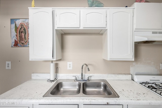 4403 N 56th Dr, Phoenix, AZ 85031 - kitchen featuring under cabinet range hood, a sink, white cabinetry, white cooktop, and light stone counters