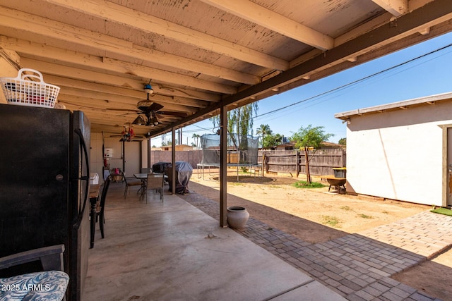 4403 N 56th Dr, Phoenix, AZ 85031 - fenced backyard with a trampoline, outdoor dining space, a patio, ceiling fan, and grilling area