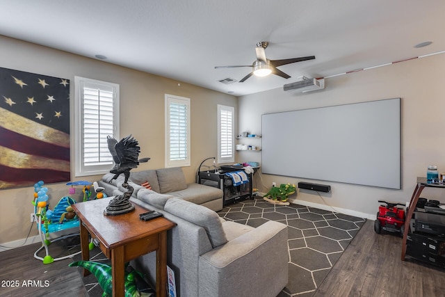 cinema with dark hardwood / wood-style floors and ceiling fan