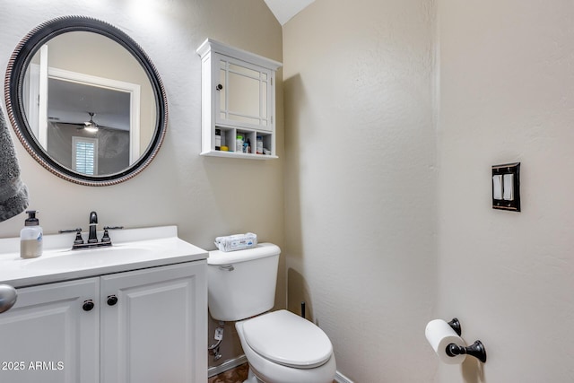 bathroom with vanity, toilet, and vaulted ceiling