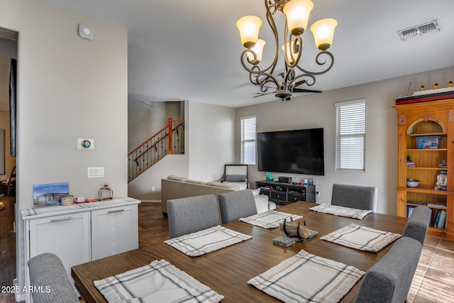 tiled dining space with a wealth of natural light and an inviting chandelier