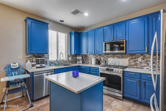 kitchen featuring a center island, blue cabinets, sink, and appliances with stainless steel finishes