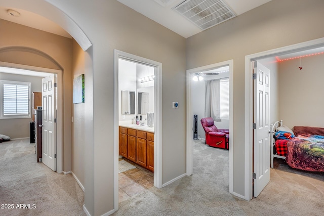 corridor with a healthy amount of sunlight and light colored carpet