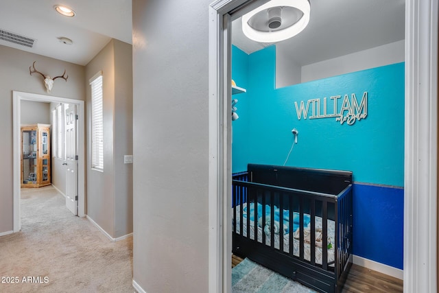 carpeted bedroom with a nursery area