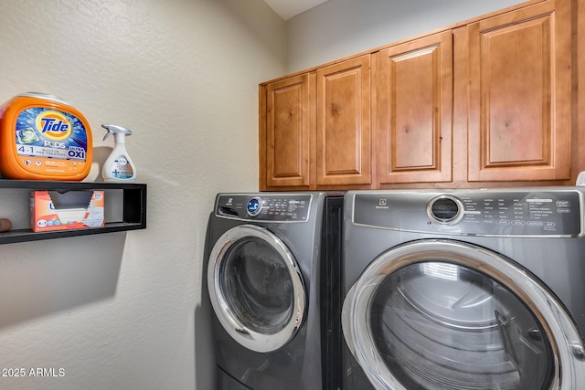 laundry area with cabinets and washer and clothes dryer