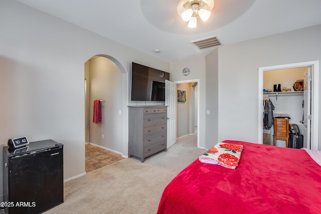 bedroom featuring ceiling fan, a closet, and light colored carpet