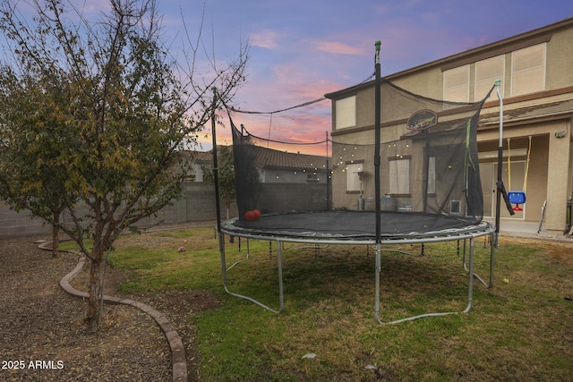 yard at dusk with a trampoline