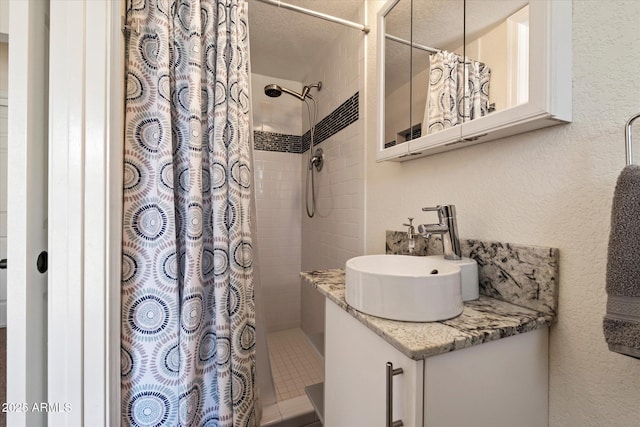 69 W Virginia Ave, Phoenix, AZ 85003 - full bathroom featuring tiled shower, vanity, and a textured wall