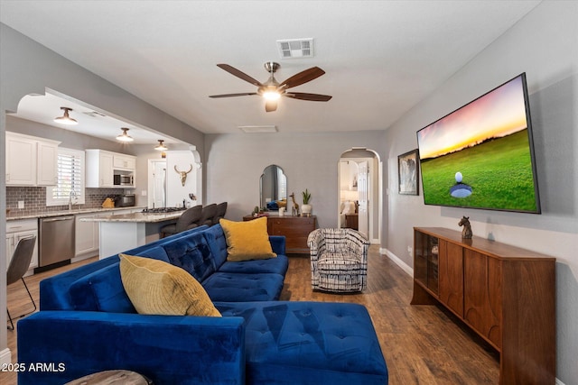 69 W Virginia Ave, Phoenix, AZ 85003 - living area featuring arched walkways, a ceiling fan, wood finished floors, and baseboards