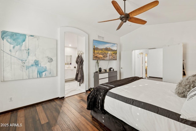 bedroom with lofted ceiling, connected bathroom, dark hardwood / wood-style floors, and ceiling fan