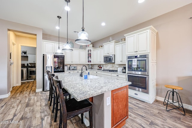 20421 W Legend Trl, Buckeye, AZ 85396 - kitchen with appliances with stainless steel finishes, a sink, light wood-style flooring, baseboards, and recessed lighting