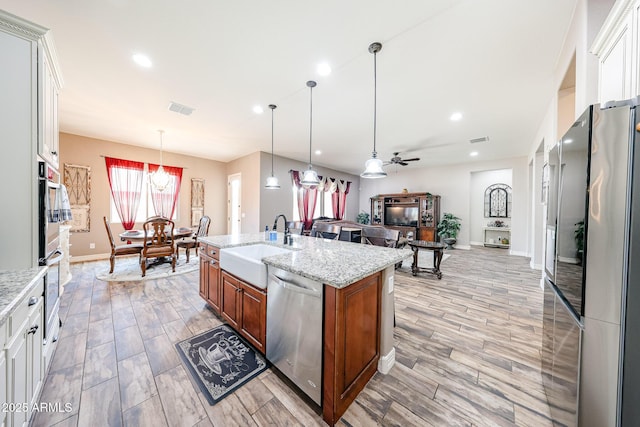 20421 W Legend Trl, Buckeye, AZ 85396 - kitchen featuring appliances with stainless steel finishes, a sink, brown cabinets, light wood-style flooring, and recessed lighting