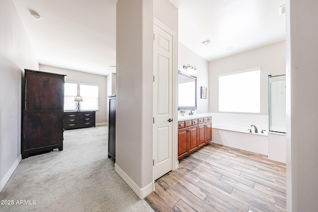20421 W Legend Trl, Buckeye, AZ 85396 - bathroom with vanity, a garden tub, baseboards, and wood finished floors