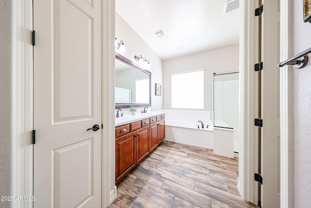 20421 W Legend Trl, Buckeye, AZ 85396 - full bathroom with double vanity, a garden tub, and wood finished floors