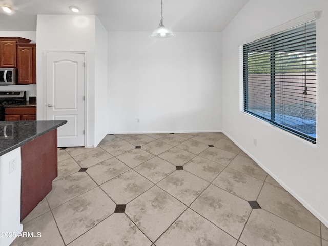 unfurnished dining area with lofted ceiling and light tile patterned flooring