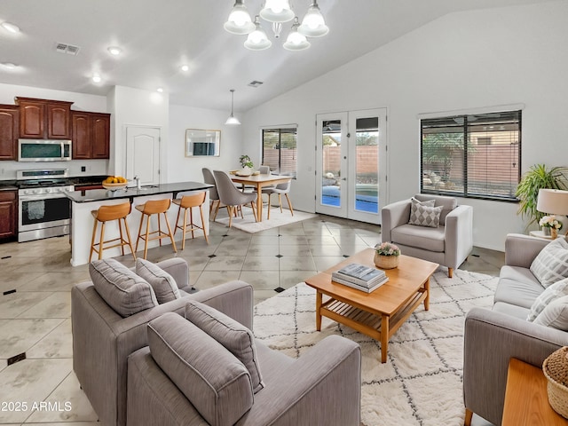 living room with light tile patterned floors, vaulted ceiling, french doors, and an inviting chandelier