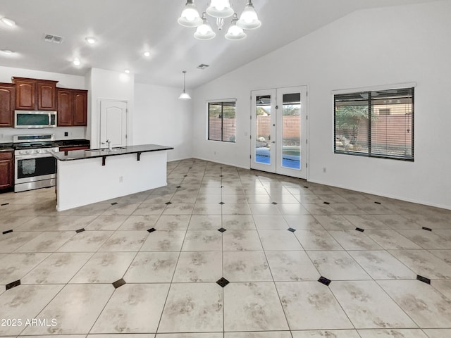 kitchen featuring pendant lighting, an inviting chandelier, appliances with stainless steel finishes, a kitchen breakfast bar, and light tile patterned floors