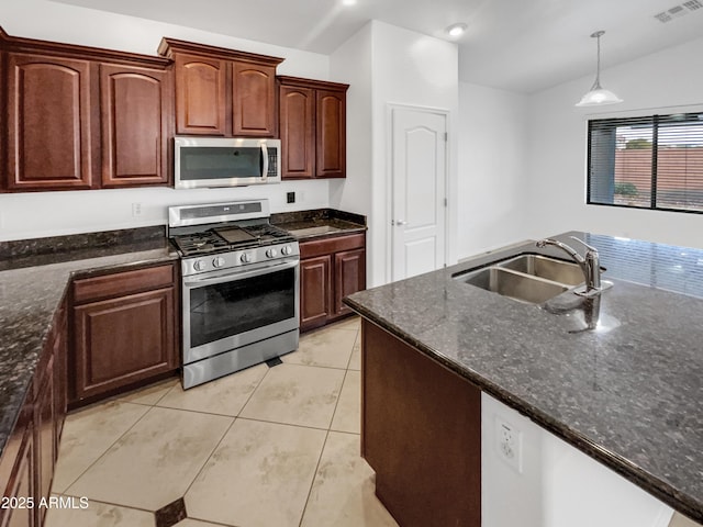 kitchen with light tile patterned floors, appliances with stainless steel finishes, lofted ceiling, hanging light fixtures, and sink