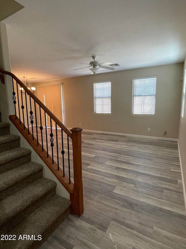 stairway with ceiling fan and wood-type flooring