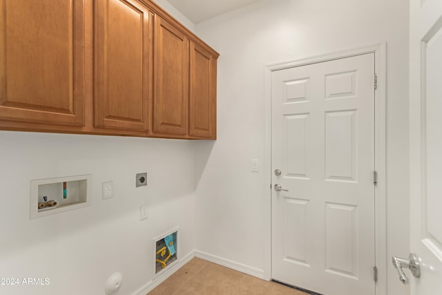 laundry room with electric dryer hookup, cabinets, gas dryer hookup, hookup for a washing machine, and light tile patterned flooring