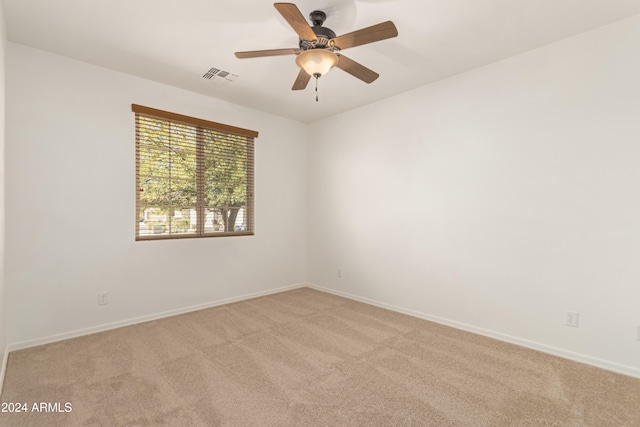 spare room with ceiling fan and light colored carpet