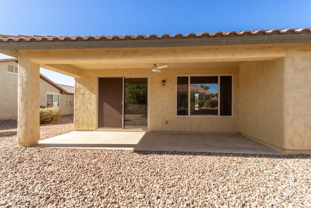 back of property with ceiling fan and a patio