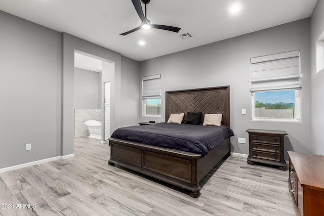 bedroom with ensuite bath, ceiling fan, light hardwood / wood-style floors, and multiple windows