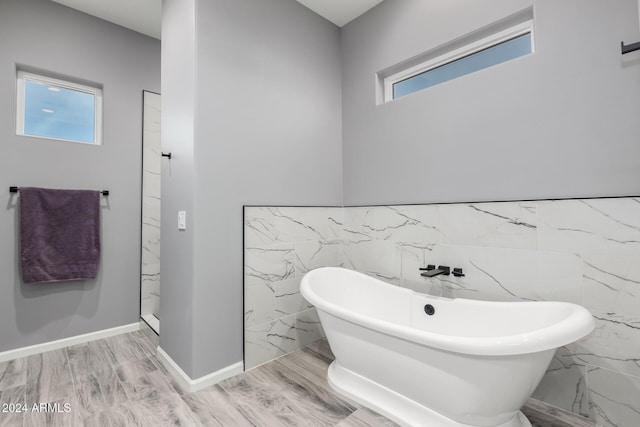 bathroom with hardwood / wood-style floors, plus walk in shower, and tile walls