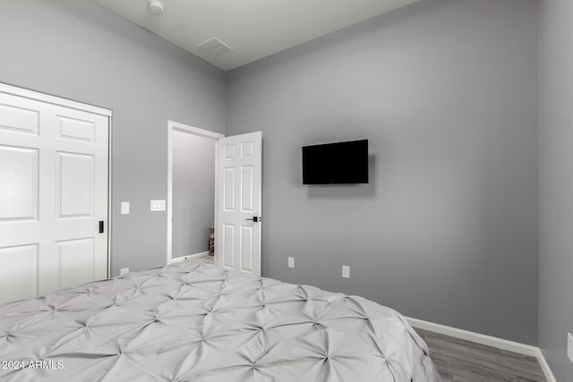 bedroom with light hardwood / wood-style floors and a closet