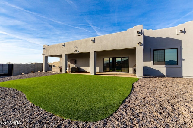 back of house with a patio area and a lawn