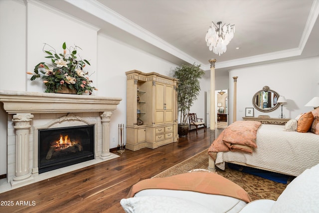 bedroom featuring crown molding, a fireplace, and dark hardwood / wood-style flooring