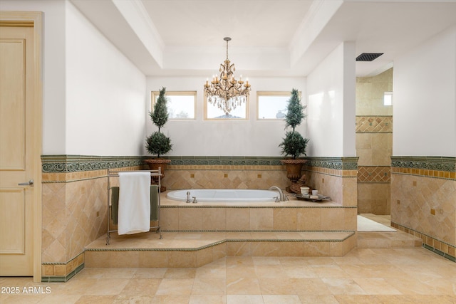 bathroom with crown molding, a tray ceiling, tile walls, and a notable chandelier