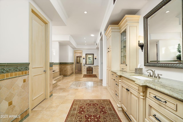 bathroom with crown molding, tile patterned floors, vanity, and tile walls